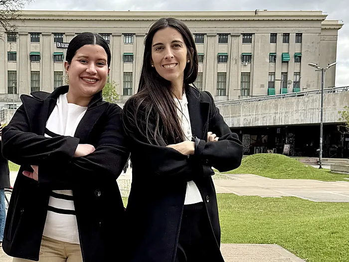Dos integrantes del equipo de Velo, sonrientes y de brazos cruzados, al aire libre