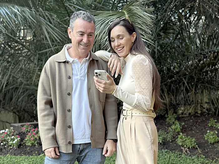 Dos integrantes del equipo de Velo mirando juntos un celular en un jardín